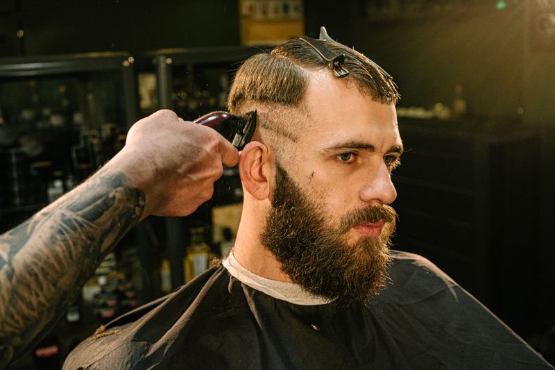 Barber blending a fade with clippers