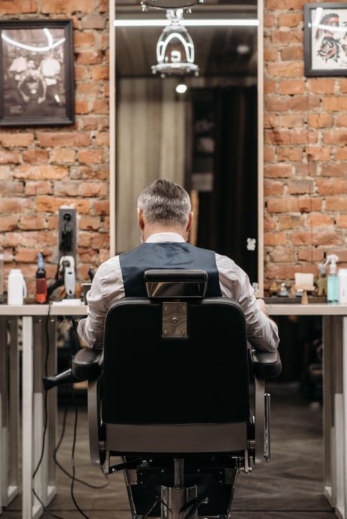 Barber at work inside a brick-walled barbershop